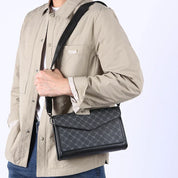 Borsa a tracolla uomo in pelle nera con motivo geometrico, indossata su giacca beige. Accessorio moda elegante e versatile.