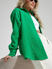 Camicia verde donna in cotone, stile casual, abbinata a top bianco e pantaloni chiari. Moda estiva, look trendy e moderno.