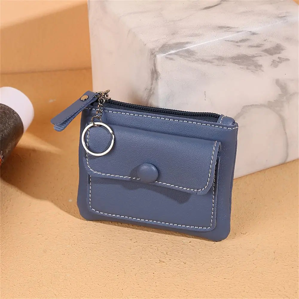 Portafoglio in pelle blu con cerniera e portachiavi, design compatto, ideale per carte e monete. Accessorio elegante e pratico per uso quotidiano.