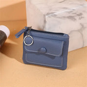 Portafoglio in pelle blu con cerniera e portachiavi, design compatto, ideale per carte e monete. Accessorio elegante e pratico per uso quotidiano.