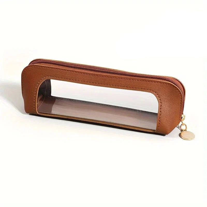 Astuccio trasparente in pelle marrone con cerniera dorata, design elegante e pratico per scuola o ufficio. Accessorio moda funzionale e chic.