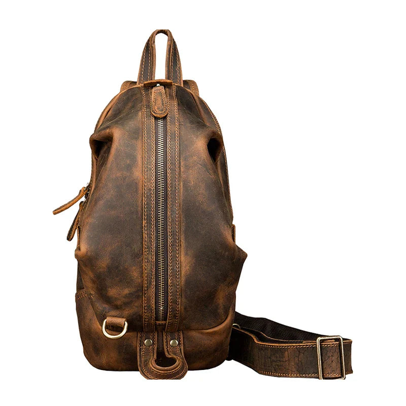 Zaino in pelle marrone vintage con cerniera centrale, tracolla regolabile e anello in metallo. Design elegante e resistente per uso quotidiano.