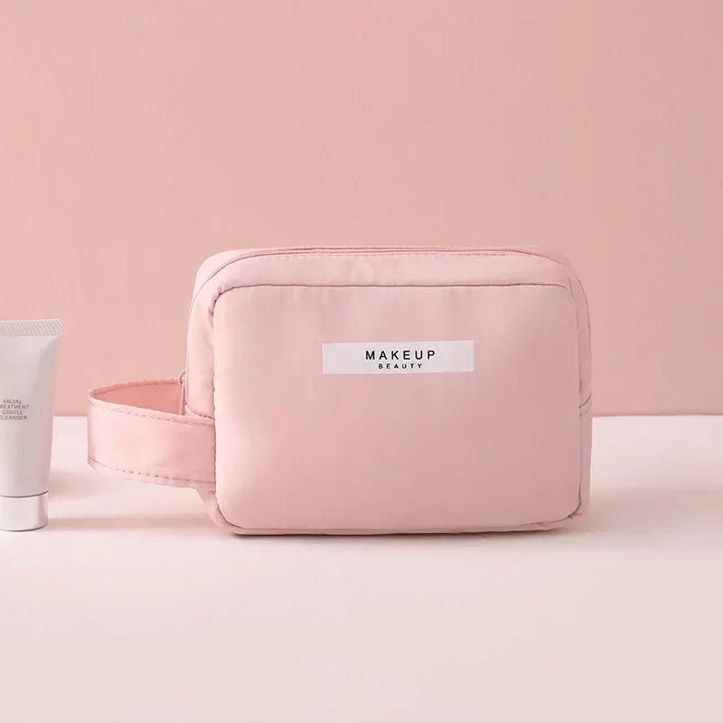 Astuccio trucco rosa con manico, design elegante, ideale per cosmetici e accessori beauty. Perfetto per viaggi e organizzazione quotidiana.