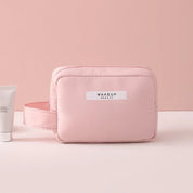 Astuccio trucco rosa con manico, design elegante, ideale per cosmetici e accessori beauty. Perfetto per viaggi e organizzazione quotidiana.