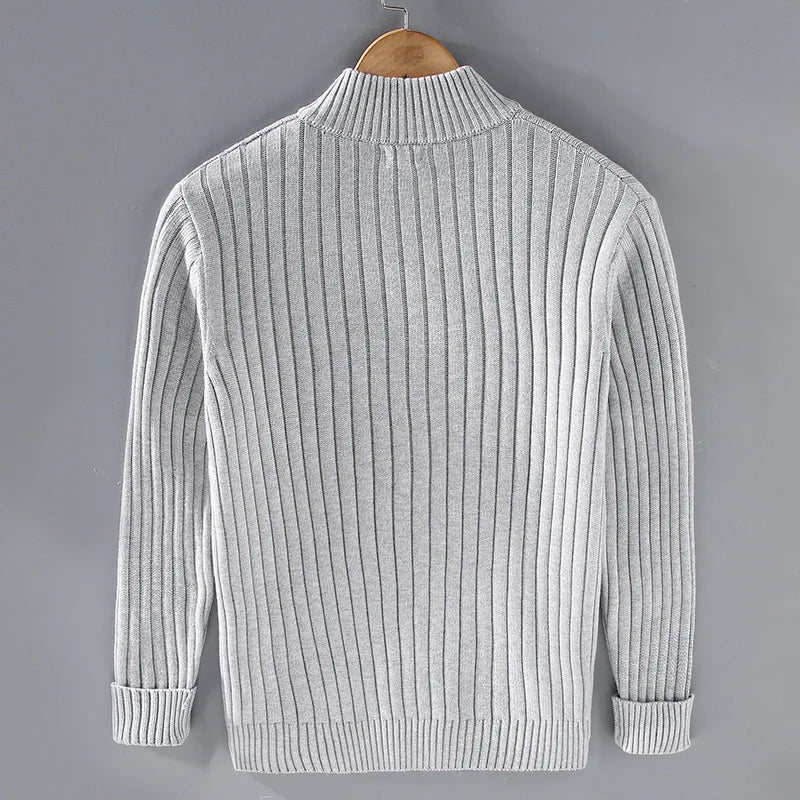 Maglione grigio a coste per uomo, maniche lunghe, collo alto, invernale, elegante, su gruccia, sfondo grigio. Perfetto per moda casual e formale.