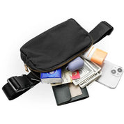 Marsupio nero con cerniera aperta, contenente smartphone, portafoglio, contanti, fazzoletti, burrocacao e crema solare. Accessorio moda pratico e versatile.