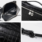 Borsa a tracolla nera in pelle effetto coccodrillo, con zip argentata e dettagli interni spaziosi. Cinturino regolabile. Elegante e versatile.