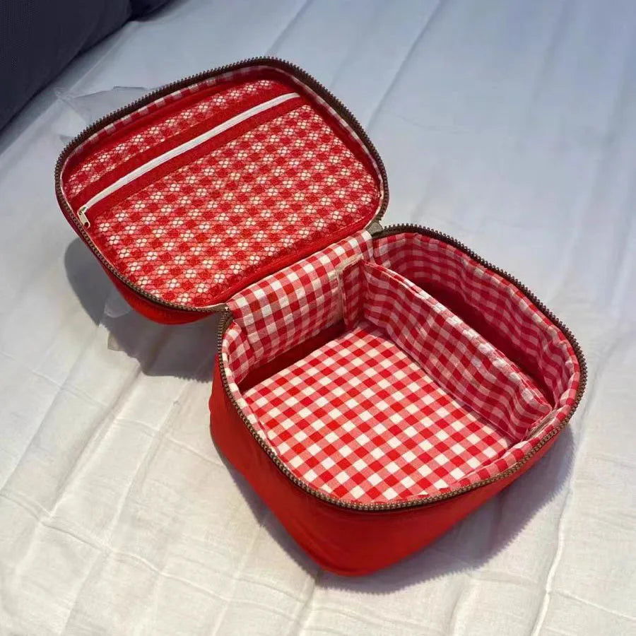 Borsa termica rossa aperta con interno a quadretti bianchi e rossi, ideale per picnic e pranzo al sacco. Design pratico e spazioso.