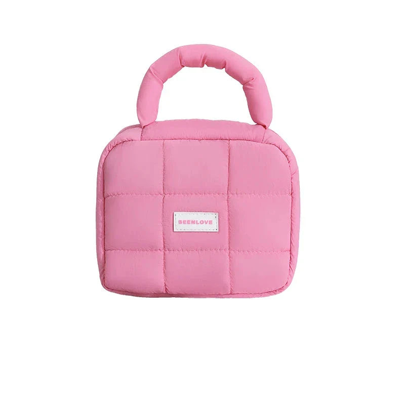 Borsa termica rosa trapuntata con manico imbottito, ideale per pranzo al sacco. Design compatto e moderno, perfetta per scuola o ufficio.