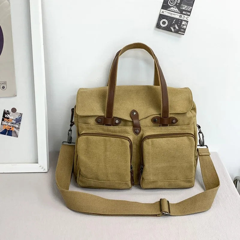 Borsa a tracolla in tela beige con manici in pelle marrone, doppie tasche frontali con cerniera, ideale per lavoro e viaggio. Design elegante e funzionale.