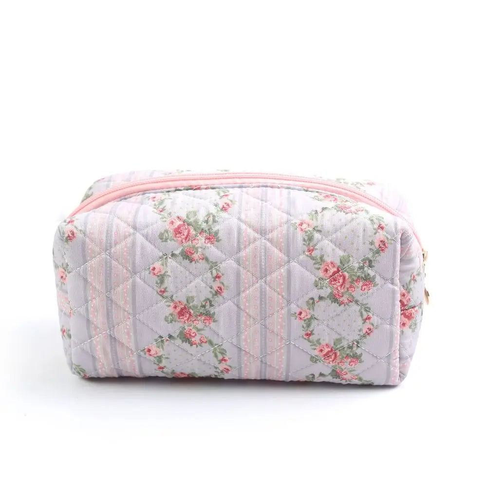 Astuccio da trucco trapuntato rosa con motivo floreale vintage, chiusura a zip. Accessorio elegante per cosmetici, ideale per viaggi e organizzazione.