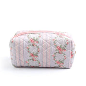 Astuccio da trucco trapuntato rosa con motivo floreale vintage, chiusura a zip. Accessorio elegante per cosmetici, ideale per viaggi e organizzazione.