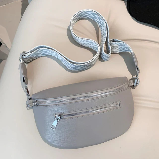 Marsupio in pelle grigia con cerniera, tracolla regolabile con motivo geometrico. Accessorio moda unisex, pratico e versatile.