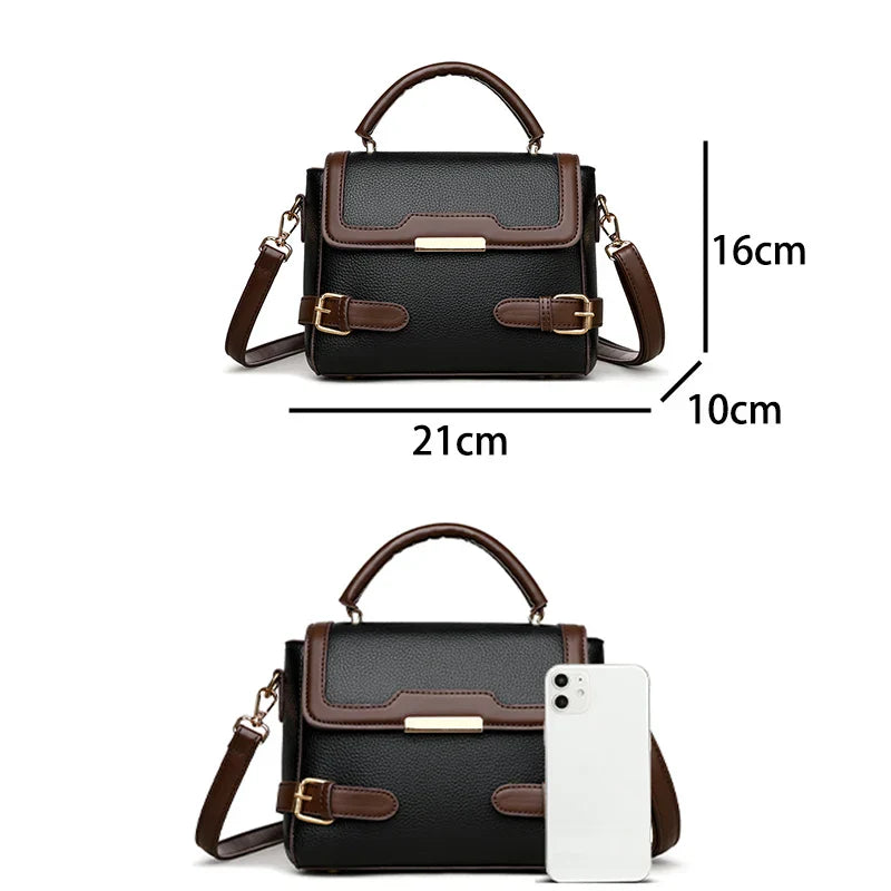 Borsa a tracolla in pelle nera e marrone, dimensioni 21x16x10 cm, con manico superiore e dettagli dorati, accanto a smartphone per confronto.