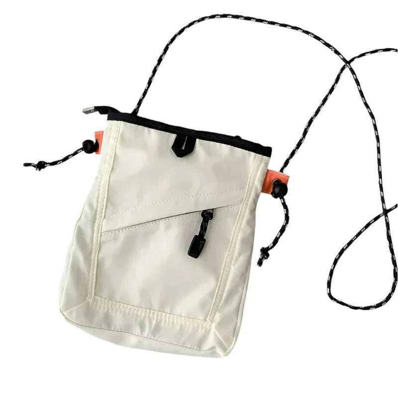 Borsa a tracolla bianca in nylon con cerniera nera, tasca frontale e cordino regolabile. Design moderno e pratico per uso quotidiano.