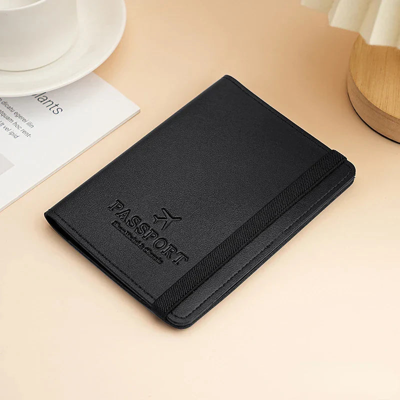 Custodia passaporto in pelle nera su tavolo beige, design elegante con elastico, ideale per viaggi, accessori viaggio, protezione documenti.