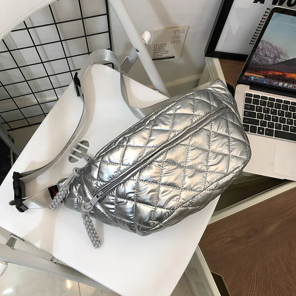 Marsupio trapuntato argento su sedia bianca, design moderno, chiusura zip, ideale per moda urbana e viaggi. Accessorio trendy e funzionale.
