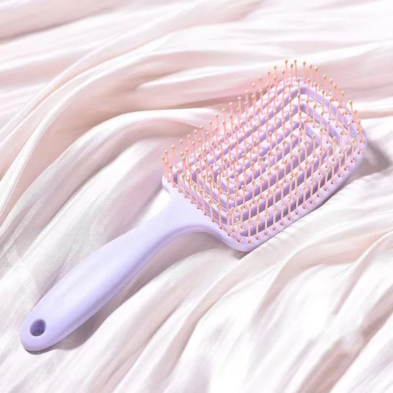 Spazzola per capelli quadrata in plastica viola con setole rosa su tessuto bianco. Accessorio per styling, cura dei capelli, bellezza quotidiana.