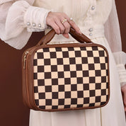 Borsa a mano donna, motivo a scacchi marrone e beige, manico imbottito, chiusura zip dorata, abito bianco elegante, moda accessori femminili.