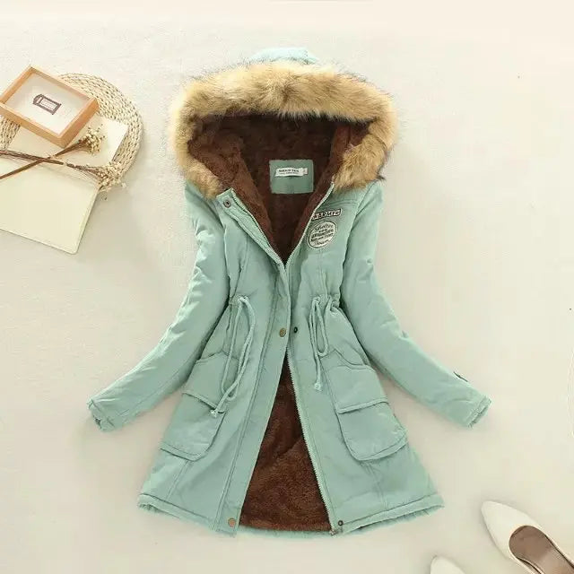 Giacca invernale donna verde menta con cappuccio in pelliccia sintetica, tasche frontali e chiusura a bottoni. Elegante e calda per l'inverno.