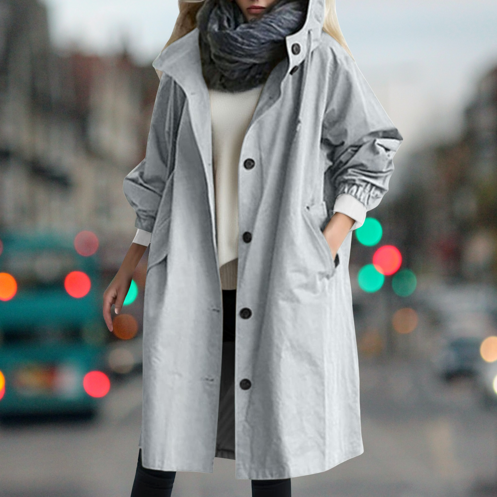 Cappotto grigio donna, elegante e moderno, con bottoni neri e tasche, perfetto per l'autunno. Sfondo urbano sfocato. Moda femminile autunnale.