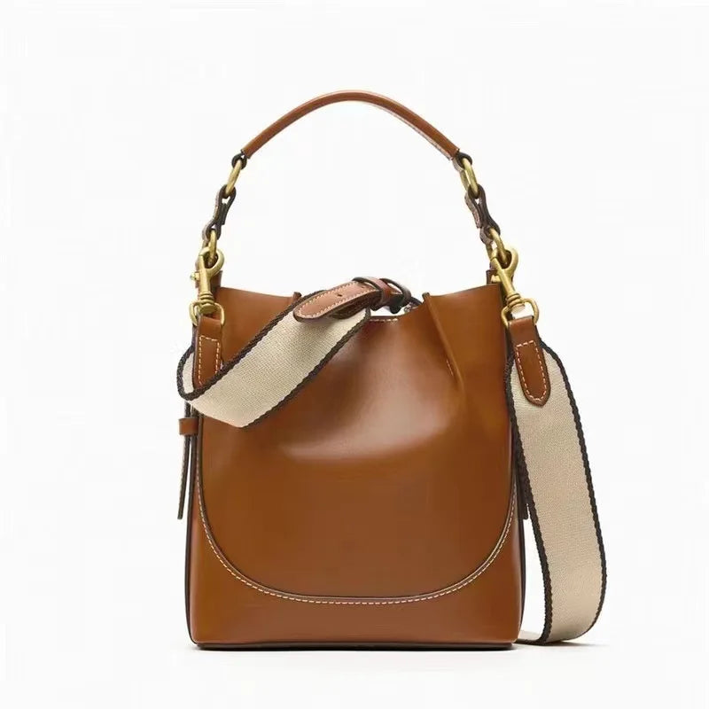 Borsa a tracolla in pelle marrone con manico e tracolla regolabile in tessuto beige, dettagli in metallo dorato. Elegante e versatile per ogni occasione.