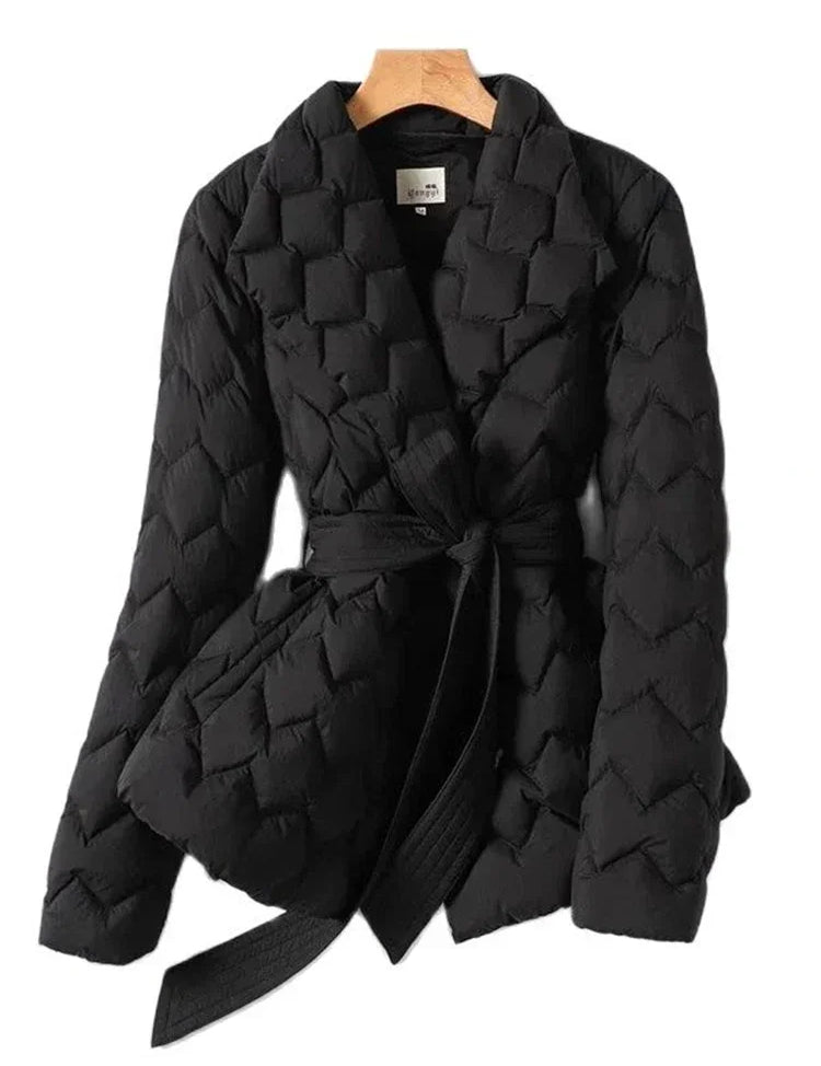 Giacca trapuntata nera da donna con cintura, design elegante e moderno, ideale per l'inverno. Tessuto caldo e confortevole, perfetto per look casual.