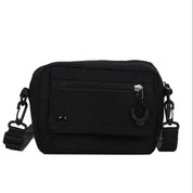 Borsa a tracolla nera unisex, compatta e resistente, con tasca frontale con zip e chiusura a bottone. Ideale per viaggi e uso quotidiano.