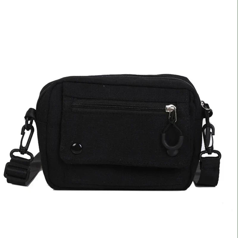 Borsa a tracolla nera unisex, compatta e resistente, con tasca frontale con zip e chiusura a bottone. Ideale per viaggi e uso quotidiano.