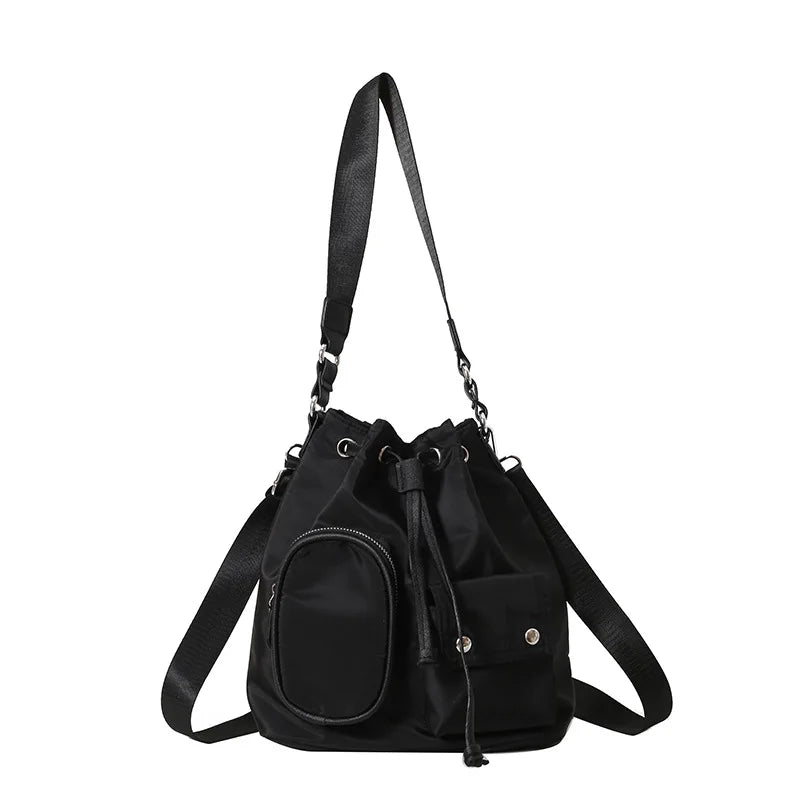 Zaino a secchiello nero in nylon con tasche multiple e tracolla regolabile, design moderno e funzionale, ideale per uso quotidiano e viaggi.