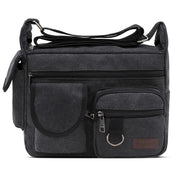Borsa a tracolla nera in tela con tasche multiple e cerniere, design unisex, ideale per viaggi e uso quotidiano. Accessorio moda pratico e resistente.