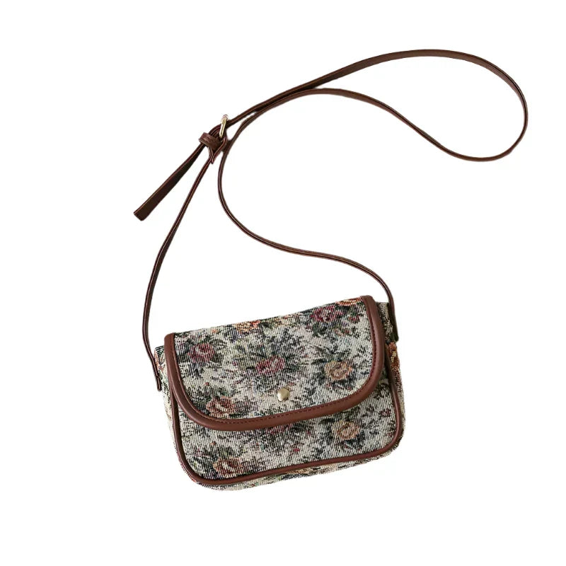 Borsa a tracolla floreale vintage in tessuto jacquard, chiusura a bottone, dettagli in pelle marrone. Accessorio moda donna elegante e retrò.