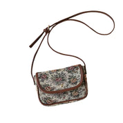 Borsa a tracolla floreale vintage in tessuto jacquard, chiusura a bottone, dettagli in pelle marrone. Accessorio moda donna elegante e retrò.
