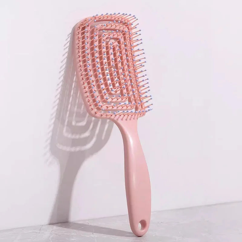 Spazzola districante rosa con setole flessibili, design ergonomico, ideale per capelli ricci e lisci. Accessorio per cura dei capelli.