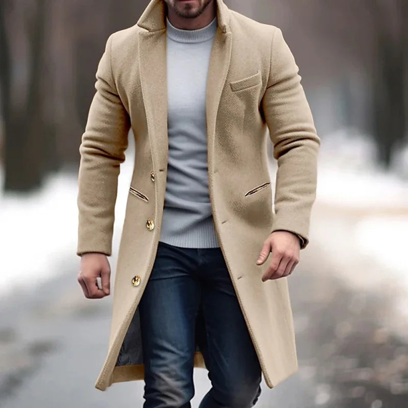 Uomo con cappotto beige elegante, maglione grigio e jeans, cammina su strada invernale. Moda maschile, abbigliamento invernale, stile casual.