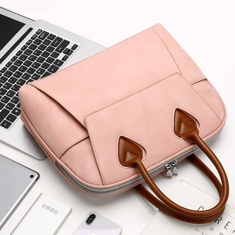 Borsa da donna rosa in pelle con manici marroni su laptop e smartphone, elegante e moderna, perfetta per lavoro e ufficio.
