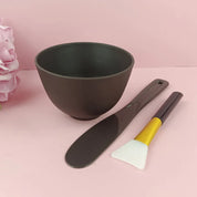 Set ciotola per maschera viso con spatola e pennello in silicone su sfondo rosa. Accessori skincare, strumenti bellezza, cura della pelle.