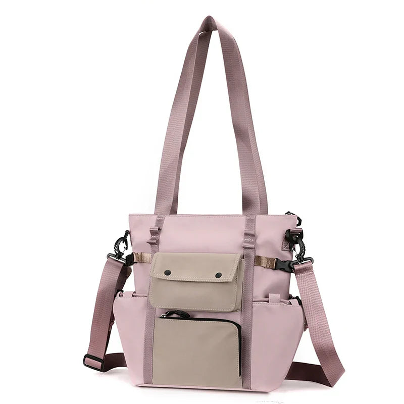 Borsa a tracolla rosa con tasche multiple, design moderno, manici lunghi, ideale per donna, moda casual, accessorio versatile e funzionale.
