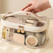 Borsa trasparente per cosmetici con cerniera, contenente pennelli trucco, cipria e profumo. Ideale per organizzare e trasportare prodotti di bellezza.