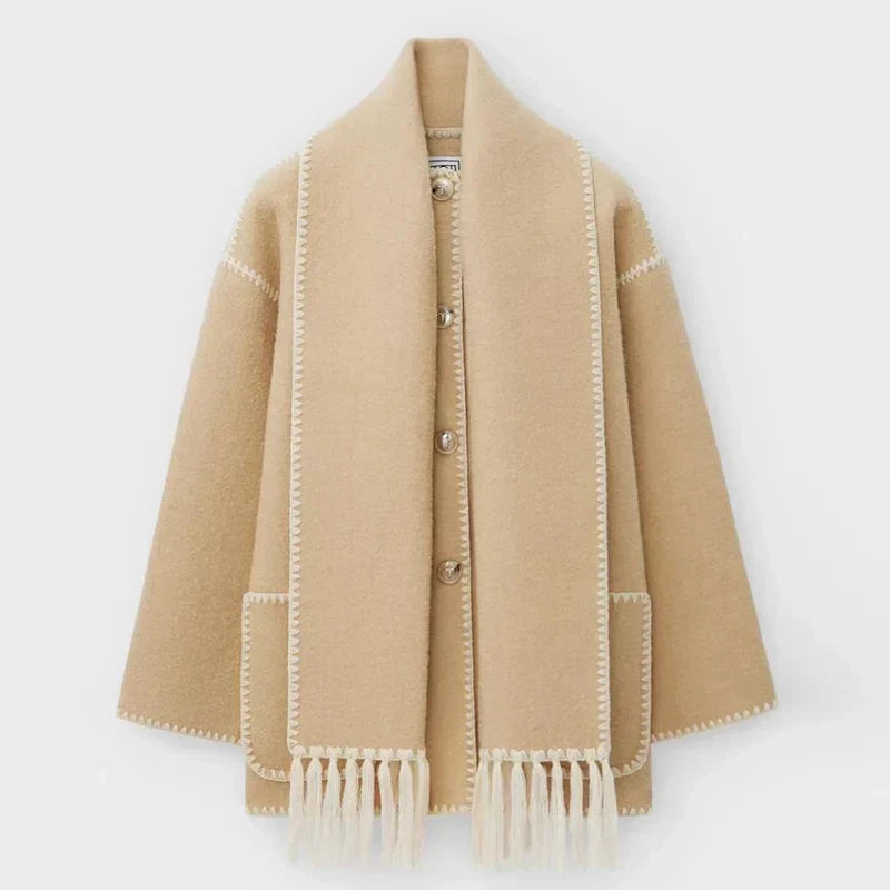 Cappotto beige in lana con frange, bottoni frontali e dettagli cuciti a contrasto. Elegante e caldo, ideale per l'inverno. Moda donna autunno inverno.