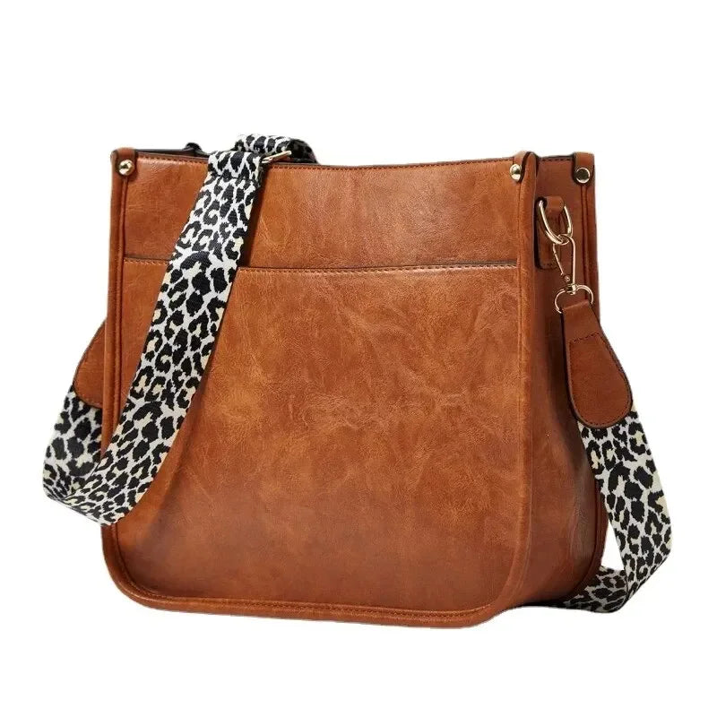 Borsa a tracolla in pelle marrone con cinturino leopardato, design elegante e spazioso, ideale per moda donna e accessori casual.