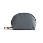 Borsa cosmetica grigia in pelle sintetica, design a mezzaluna, con cerniera e manico in pelle marrone. Accessorio elegante e pratico per viaggio.