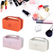 Tre eleganti beauty case in diversi colori con prodotti cosmetici, tra cui rossetti, pennelli e profumo. Accessori trucco essenziali e di tendenza.