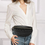 Donna con marsupio nero trapuntato, indossa camicia bianca e jeans. Accessorio moda elegante, chiusura zip, ideale per look casual e chic.