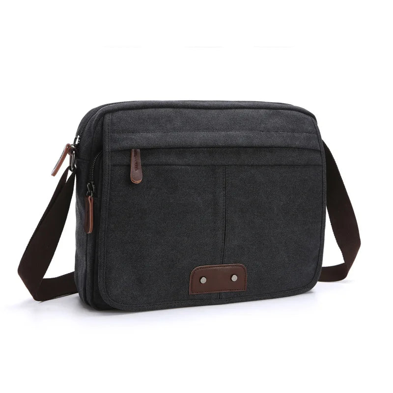 Borsa a tracolla uomo in tela nera, design elegante e funzionale, con tasche multiple e dettagli in pelle marrone. Accessorio moda versatile.