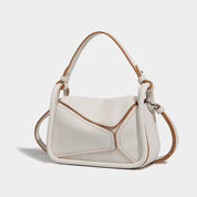 Borsa a tracolla in pelle bianca con dettagli marroni, design geometrico moderno, manico regolabile. Accessorio moda elegante e versatile.