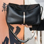 Borsa a tracolla in pelle nera con striscia centrale, design elegante e moderno, ideale per moda donna, accessorio versatile e di tendenza.