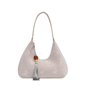 Borsa a spalla elegante in pelle beige con motivo floreale, decorata con nappina e perla. Accessorio moda donna, stile chic e raffinato.
