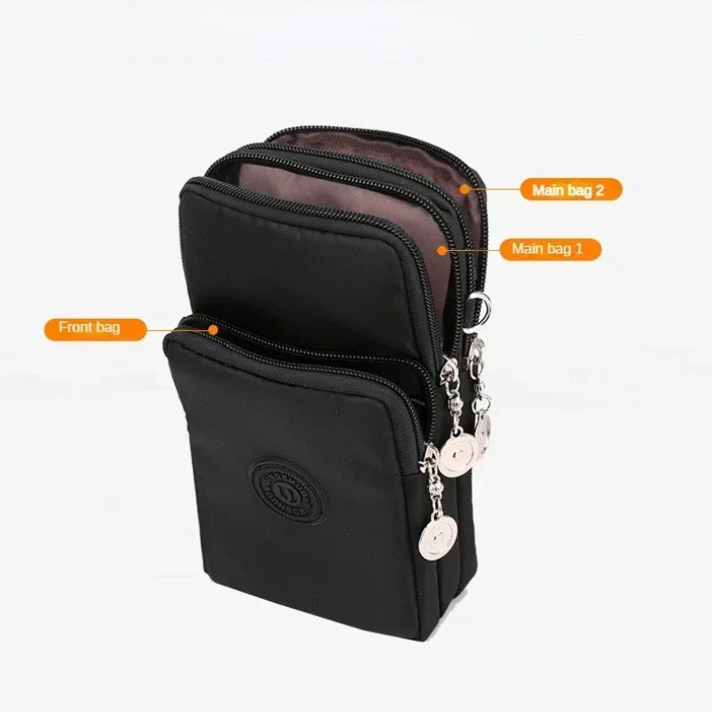 Borsa a tracolla nera in nylon con tre scomparti, cerniere argentate, design compatto e logo frontale. Ideale per viaggi e uso quotidiano.