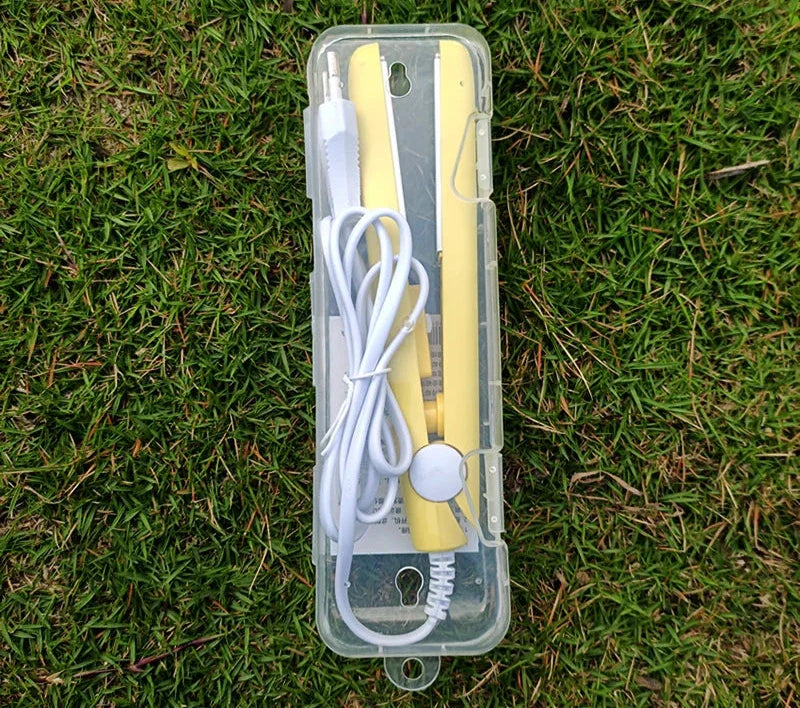 Custodia trasparente con termometro digitale giallo e cavo bianco su erba verde. Accessorio medico portatile, misurazione temperatura precisa.